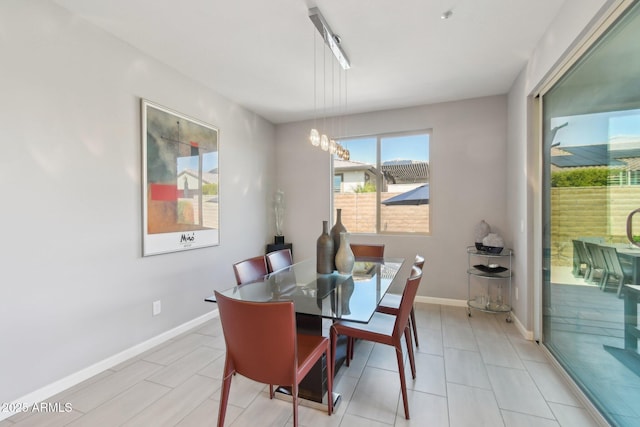 dining room featuring a notable chandelier and baseboards