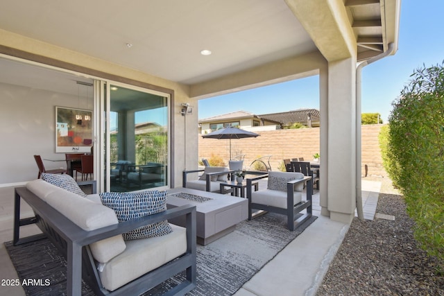 view of patio / terrace featuring an outdoor living space with a fire pit and fence