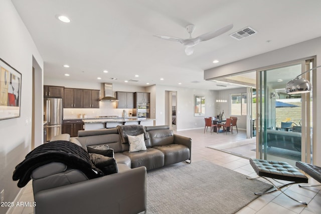 living room with visible vents, baseboards, light tile patterned floors, recessed lighting, and a ceiling fan