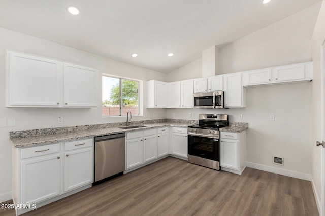 1727 W 12th Ave, Apache Junction, AZ 85120 - kitchen featuring stainless steel appliances, white cabinetry, vaulted ceiling, light wood finished floors, and light stone countertops