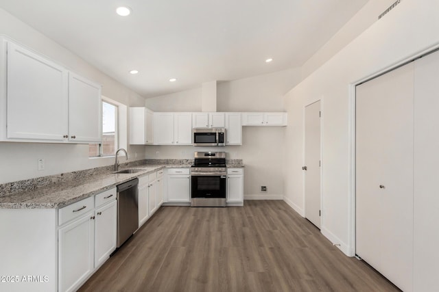 1727 W 12th Ave, Apache Junction, AZ 85120 - kitchen featuring stainless steel appliances, light wood finished floors, white cabinetry, vaulted ceiling, and light stone counters