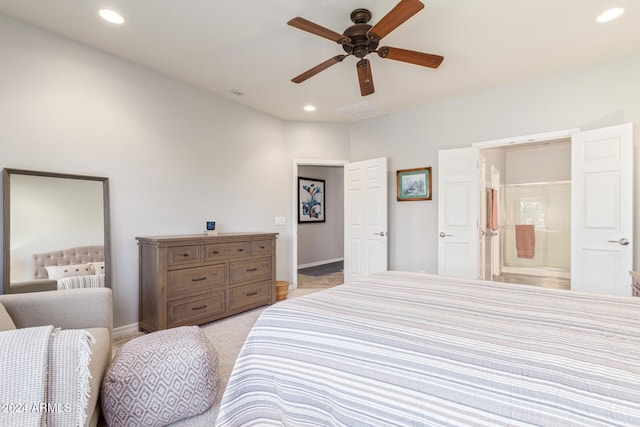 carpeted bedroom with ensuite bathroom and ceiling fan