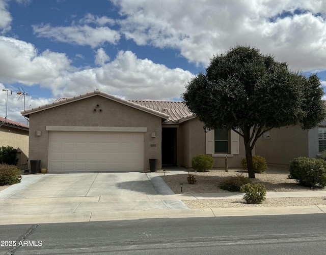 view of front of property featuring stucco siding, a garage, concrete driveway, and a tiled roof