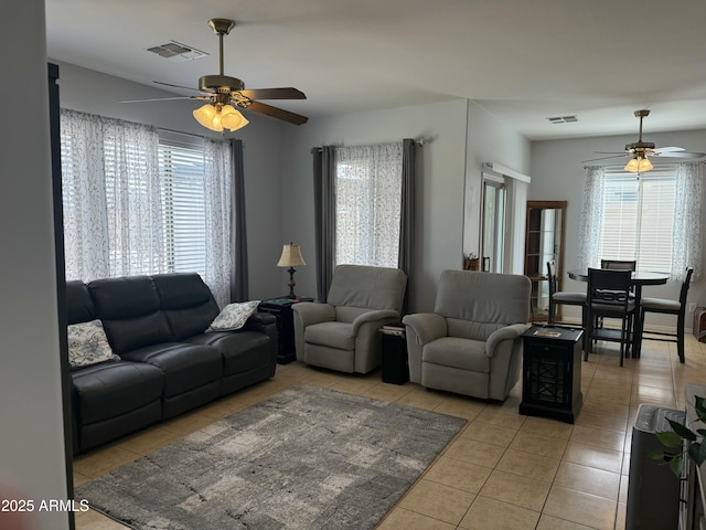 living room featuring a wealth of natural light, visible vents, and tile patterned flooring