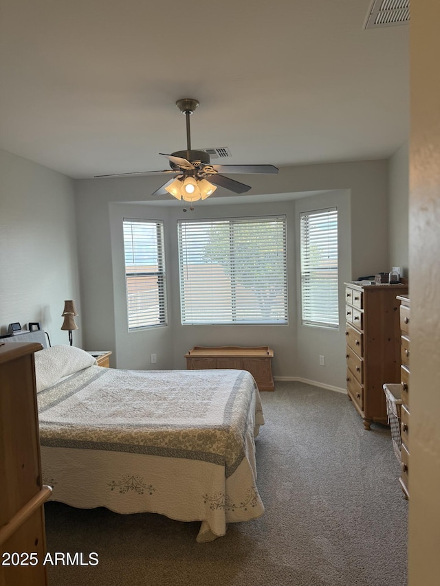 bedroom featuring visible vents, multiple windows, carpet flooring, and ceiling fan