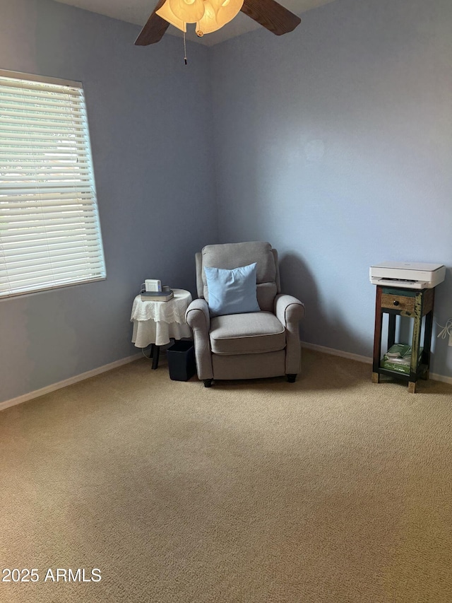 living area with carpet flooring, baseboards, and ceiling fan