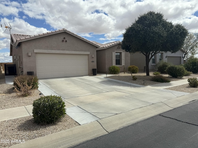 ranch-style house with a tiled roof, an attached garage, driveway, and stucco siding