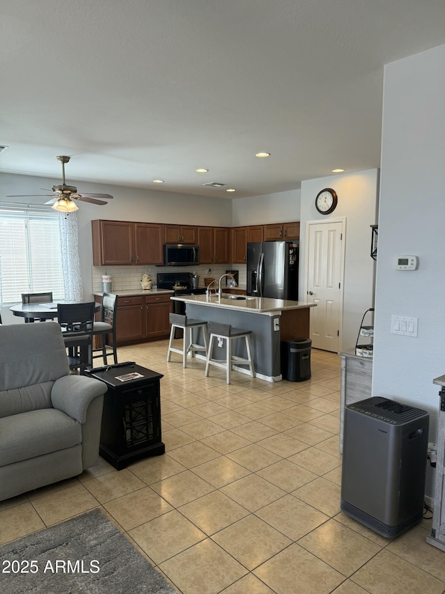 living room with light tile patterned flooring, a ceiling fan, and recessed lighting