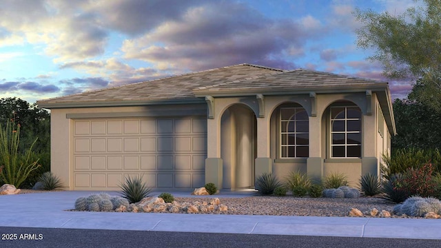 view of front facade featuring driveway, a garage, and stucco siding