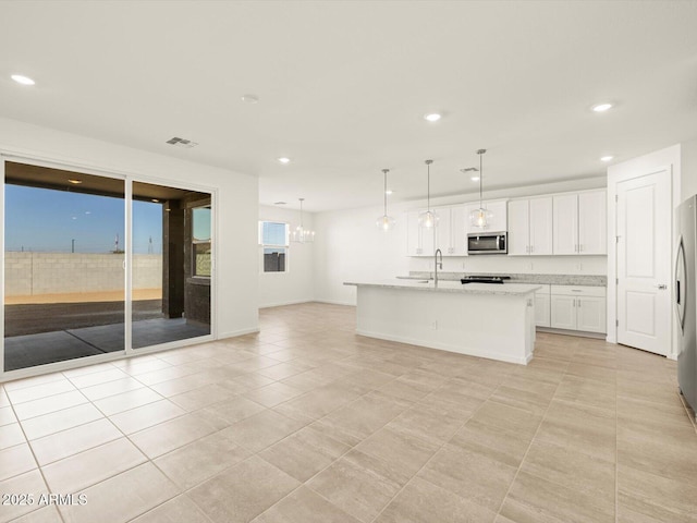 kitchen with white cabinetry, stainless steel appliances, an island with sink, sink, and hanging light fixtures