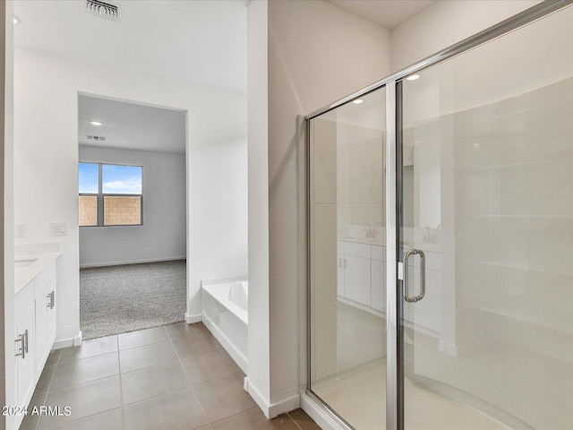 bathroom featuring shower with separate bathtub, tile patterned floors, and vanity