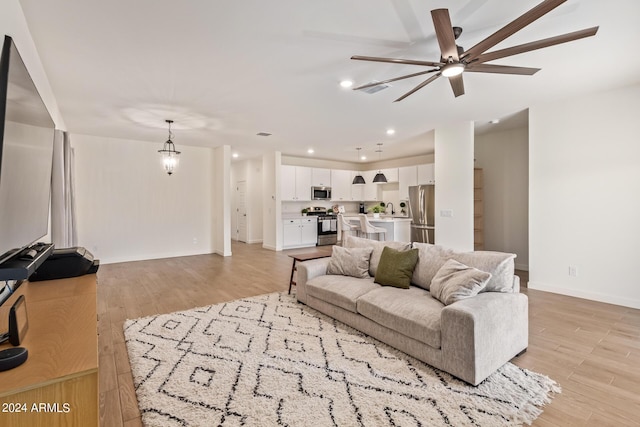 living room featuring ceiling fan and light wood-type flooring