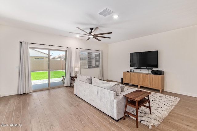 living room featuring ceiling fan and light hardwood / wood-style flooring