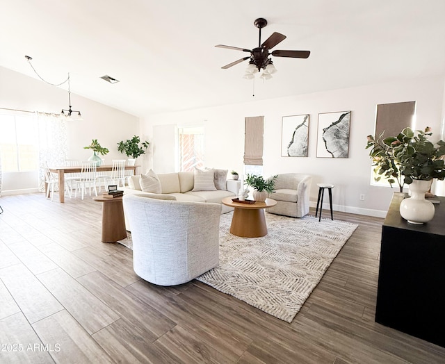 living room with ceiling fan with notable chandelier and wood-type flooring