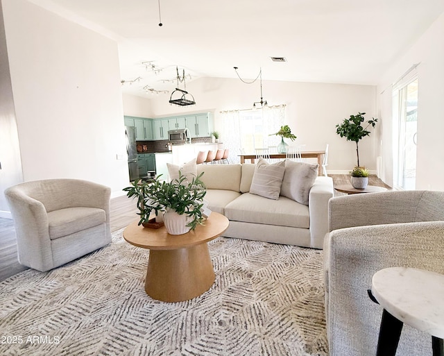 living room with light wood-type flooring and vaulted ceiling