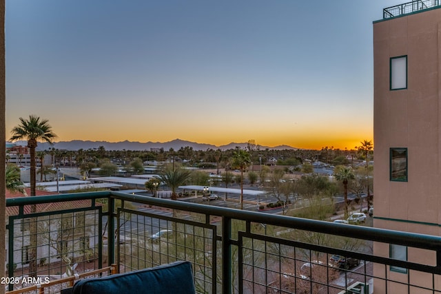 balcony at dusk featuring a mountain view