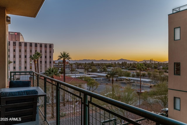 balcony at dusk featuring a mountain view