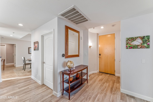 hallway with light hardwood / wood-style floors