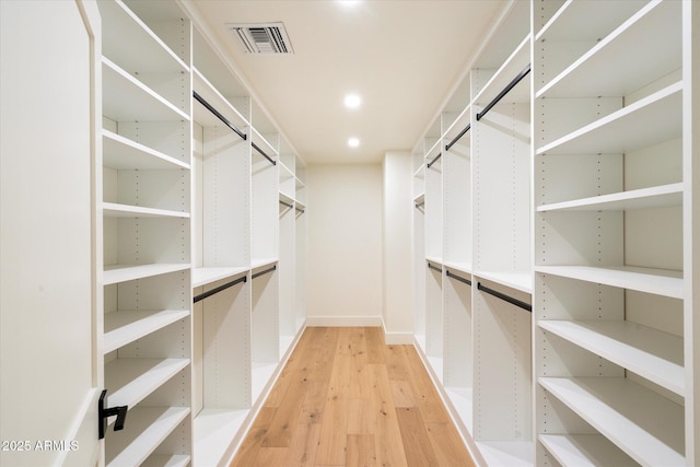 walk in closet with light wood-type flooring and visible vents