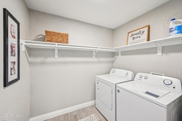 washroom featuring laundry area, light wood finished floors, baseboards, and washer and dryer