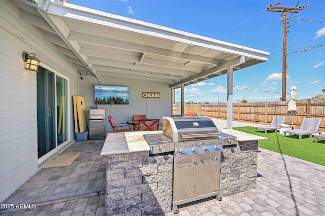view of patio with an outdoor kitchen and a fenced backyard