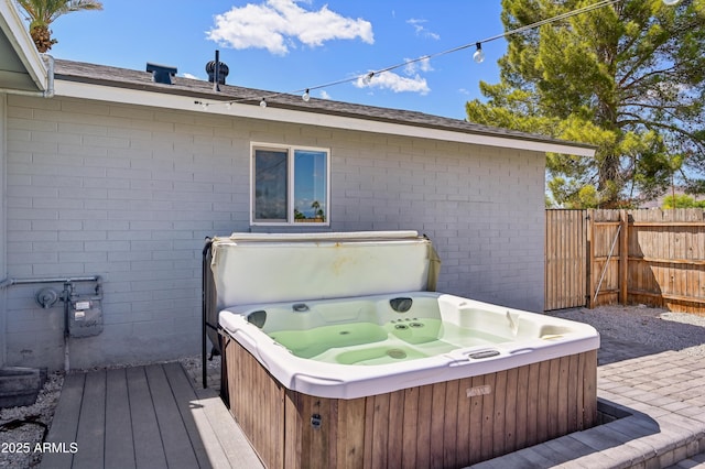 wooden deck featuring a hot tub and fence