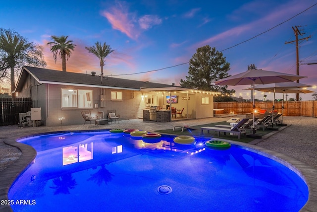 view of pool with a patio, fence, outdoor dry bar, and a fenced in pool