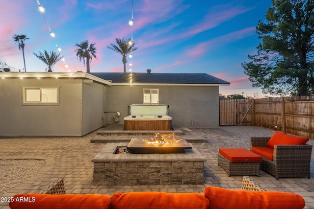 back of house with fence, an outdoor living space with a fire pit, a hot tub, and a patio area