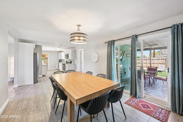 dining room featuring baseboards, wood finish floors, and a chandelier