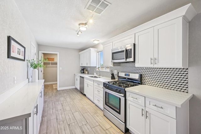 kitchen featuring visible vents, decorative backsplash, appliances with stainless steel finishes, and light countertops