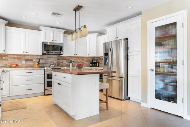 12212 N 66th St, Scottsdale, AZ 85254 - kitchen featuring appliances with stainless steel finishes, tasteful backsplash, white cabinets, light tile patterned floors, and recessed lighting