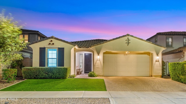 mediterranean / spanish-style home with a yard and a garage