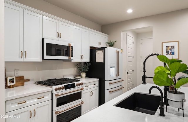 kitchen with sink, white cabinets, and white appliances