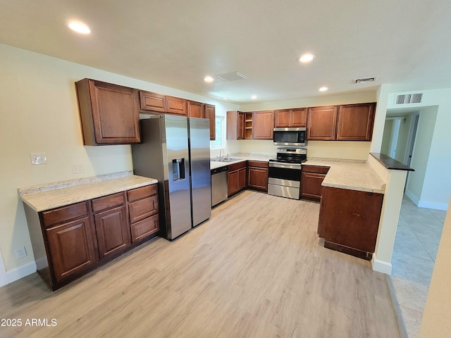 kitchen featuring baseboards, appliances with stainless steel finishes, a sink, and visible vents