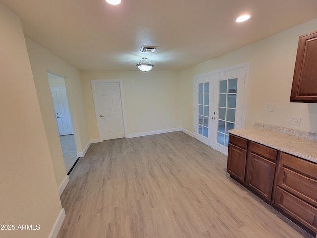unfurnished dining area featuring french doors, light wood-type flooring, baseboards, visible vents, and recessed lighting