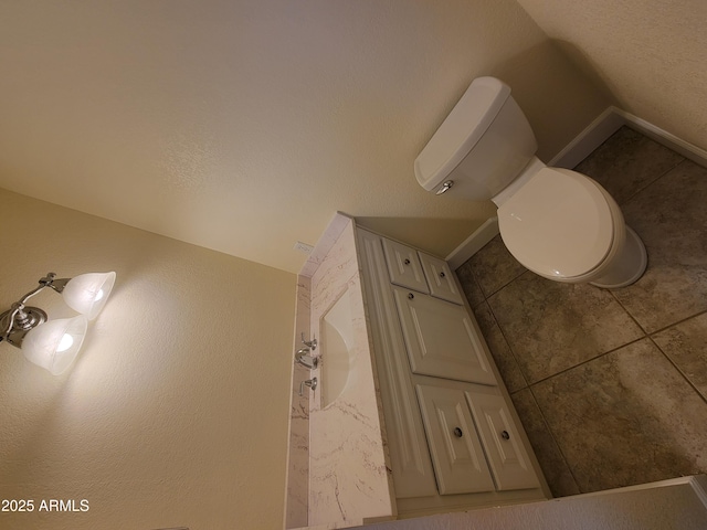 bathroom with toilet, tile patterned flooring, and baseboards