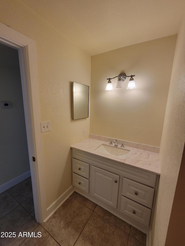 bathroom featuring tile patterned flooring, baseboards, and vanity