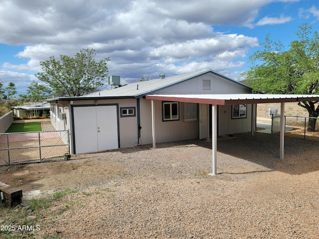 rear view of house with fence and an attached carport