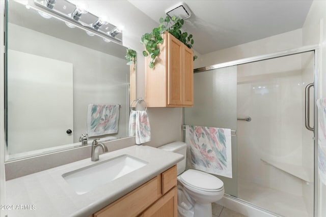 bathroom with tile patterned floors, vanity, an enclosed shower, and toilet