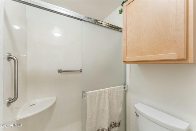 bathroom featuring walk in shower and toilet