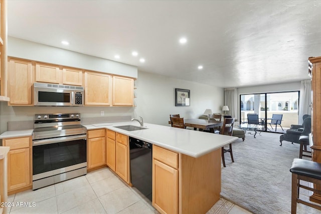 kitchen featuring light brown cabinets, sink, appliances with stainless steel finishes, light colored carpet, and kitchen peninsula