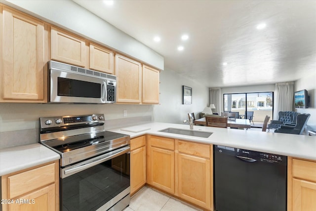 kitchen featuring light tile patterned flooring, light brown cabinets, stainless steel appliances, and sink