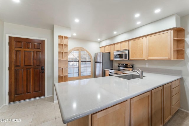 kitchen featuring light brown cabinetry, kitchen peninsula, sink, and appliances with stainless steel finishes