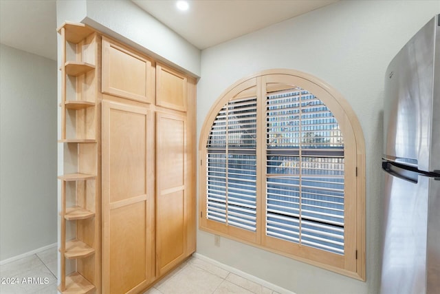 interior details with light brown cabinetry and stainless steel refrigerator