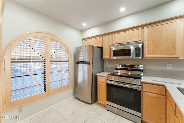 kitchen featuring light brown cabinets, light tile patterned flooring, and appliances with stainless steel finishes