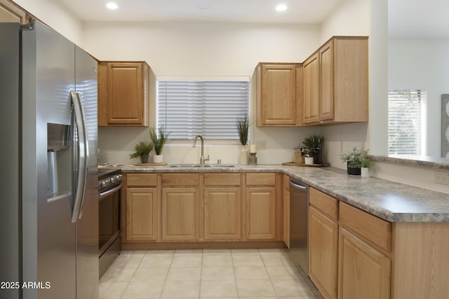 kitchen featuring stainless steel appliances, sink, and light tile patterned floors