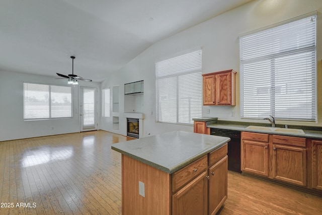 kitchen with dishwasher, light wood-type flooring, a center island, ceiling fan, and sink