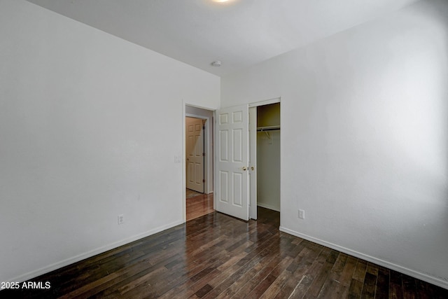 unfurnished bedroom featuring a closet and dark hardwood / wood-style floors