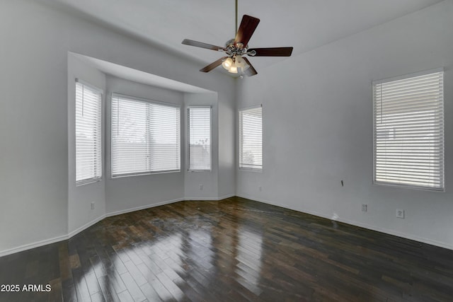 unfurnished room with ceiling fan, plenty of natural light, and dark wood-type flooring