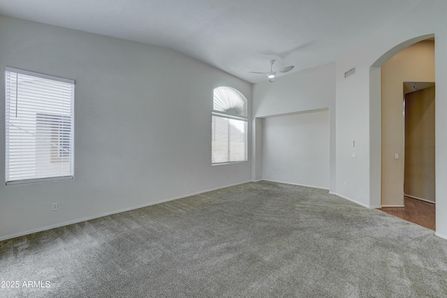 empty room featuring vaulted ceiling, ceiling fan, and carpet